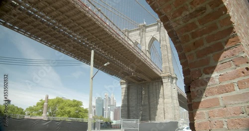 Brooklyn bridge revealed through brick building, warehouse 