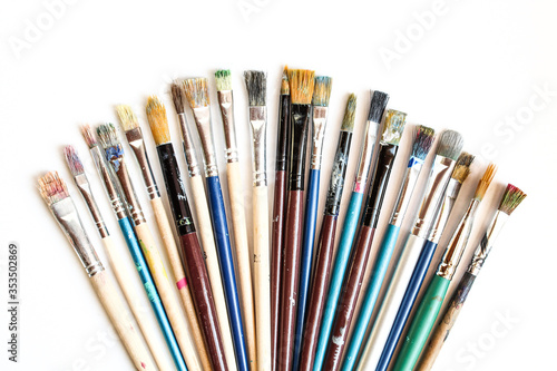 Set of dirty used paint bristles isolated on white background. Paint brushes in various colors