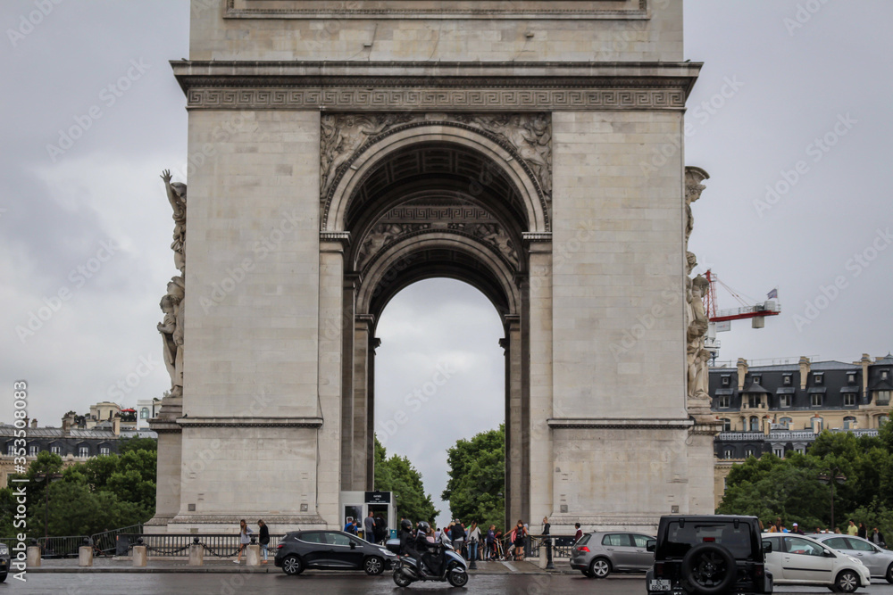 Arc de Triomphe in Paris on a gloomy day with cars driving past