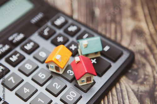 A calculator and several colored houses. The concept of buying a home on credit or a mortgage photo
