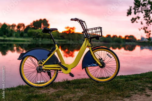 Yellow bike on the lake. Sunset. photo