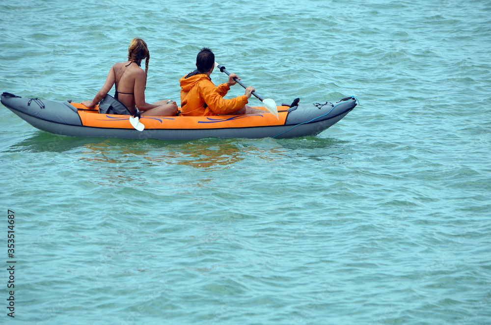 Young couple on biscayne bay off Miami Beach in an inflated canoe.