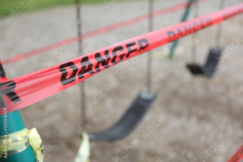 Danger tape is wrapped around playground equipment, indicating the park is closed due to Covid-19 concerns. © Ron Alvey