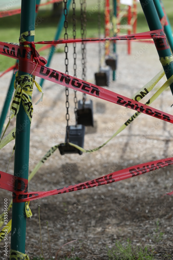 Danger tape is wrapped around playground equipment, indicating the park is closed due to Covid-19 concerns. Danger tape is wrapped around playground equipment, indicating the park is closed due to Covid-19 concerns.