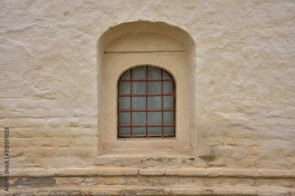 window with bars in fortress wall, loophole with bars