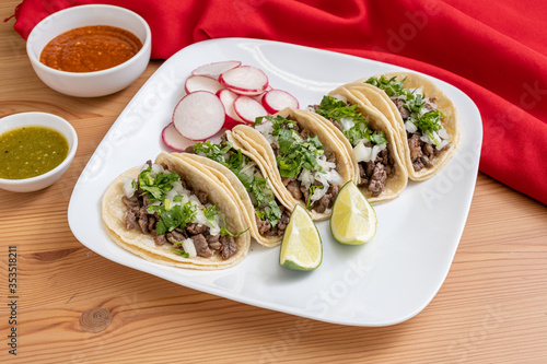 Carne asada taco plate. Authentic Mexican street tacos made with marinated steak, cilantro, and diced onions, served on corn tortillas. 
