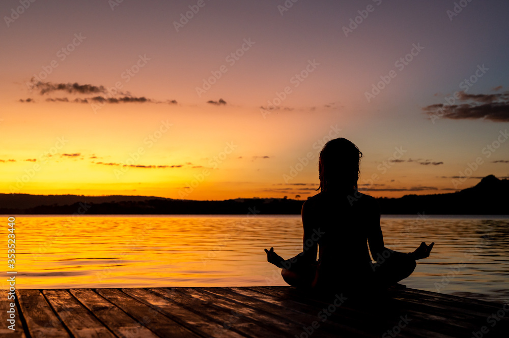 meditação no por do sol com lago ao fundo