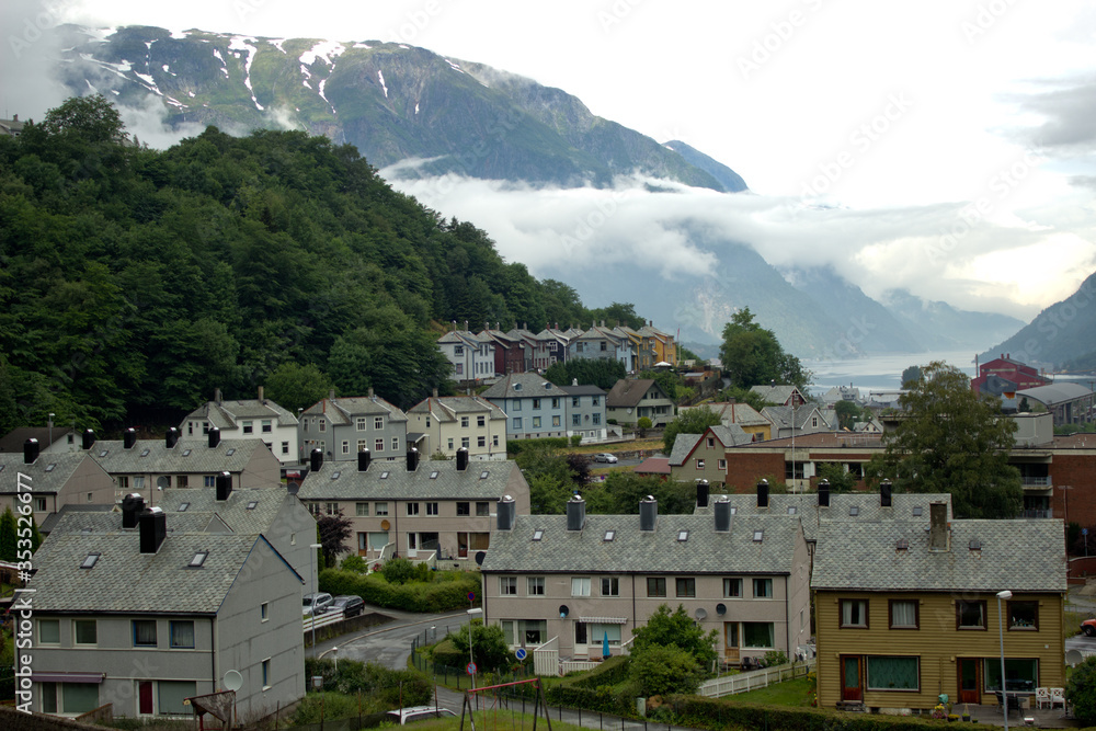 Obraz premium Cityscape of Tyssedal village near Odda,Norway,houses with old norwegian traditional roof,scandinavian nature,morning beauty,gloomy day with low clouds,print for wallpaper,poster,cover design,calendar