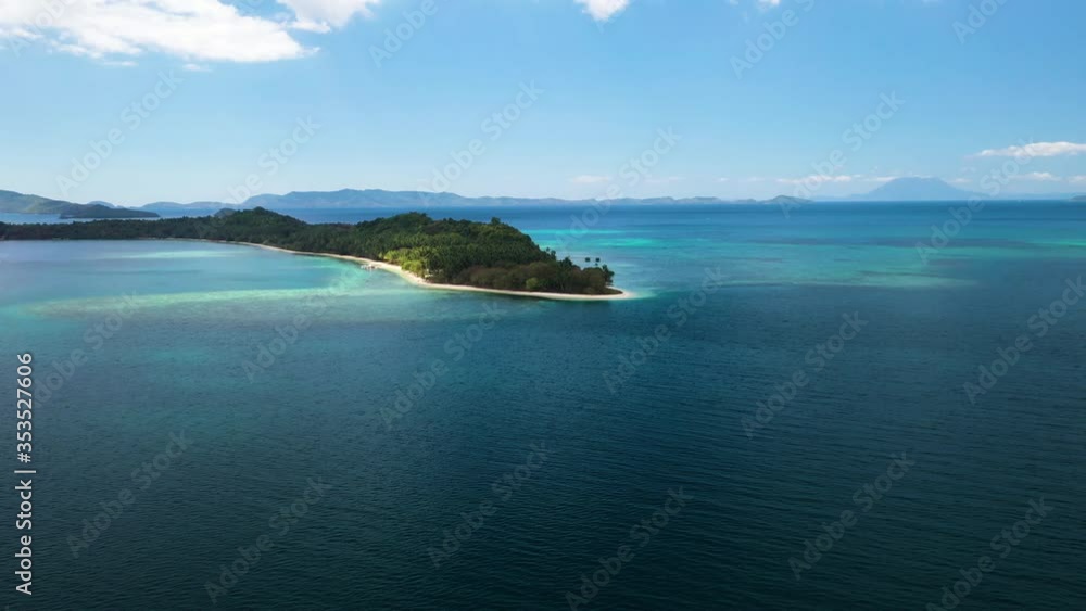 Forward drone shot in Port Barton with white sand coastline middle of blue sea and mountains in far BG;sunlight falling on trees gives serene feeling Forward drone shot in Port Barton with white sand coastline middle of blue sea and mountains in far BG;sunlight falling on trees gives serene feeling