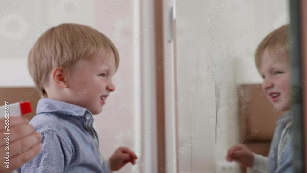 cleaning house, cute little children spray cleaning detergent on mirror and wash it with a cleaning cloth in room of house, window cleaner on face of child cleaning house, cute little children spray cleaning detergent on mirror and wash it with a cleaning cloth in room of house, window cleaner on face of child