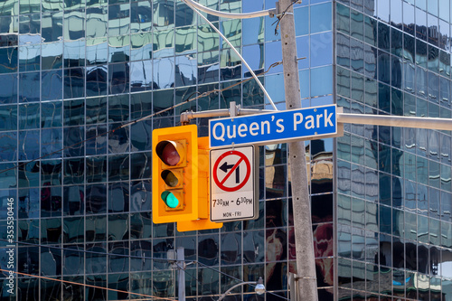 Photography Street sign of Queen's Park Crescent with traffic light in downtown Toronto Canada