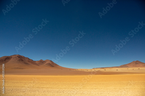 Salvador Dali desert on a Clear Blue Sky Day with Dream Like Yellow Sand and Mountain Ranges near Uyuni Salt Flat