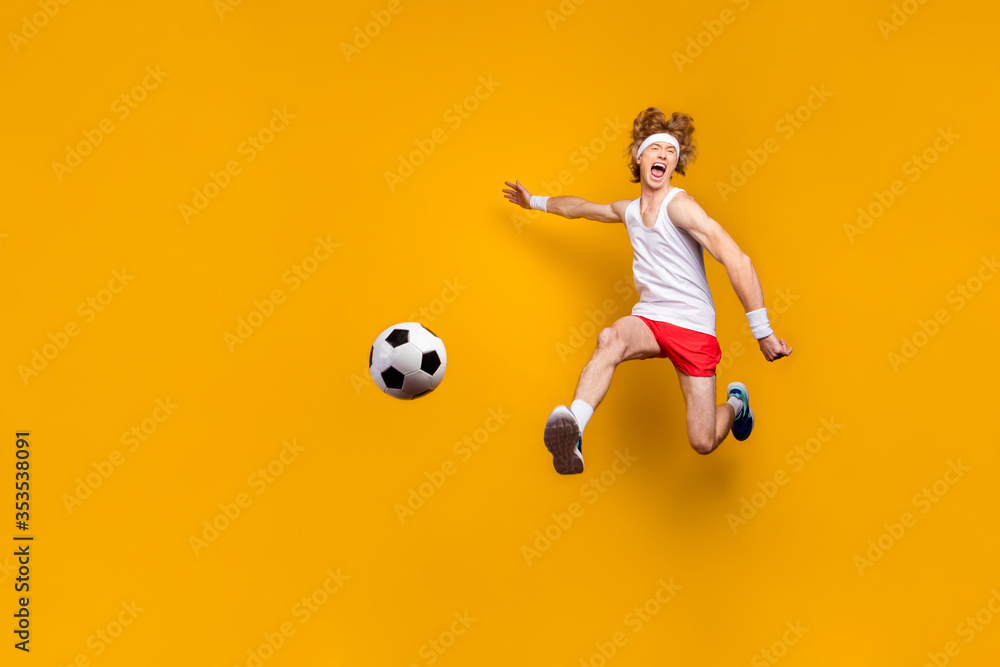 Full length body size view of nice funky crazy overjoyed ecstatic glad excited cheerful cheery motivated guy jumping playing soccer isolated over bright vivid shine vibrant yellow color background