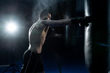 Male boxer hitting a huge punching bag at a boxing studio. man boxer training hard