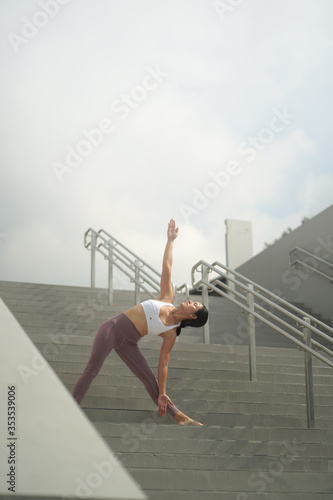 Street Yoga - Asian Chinese Woman doing yoga in public spaces