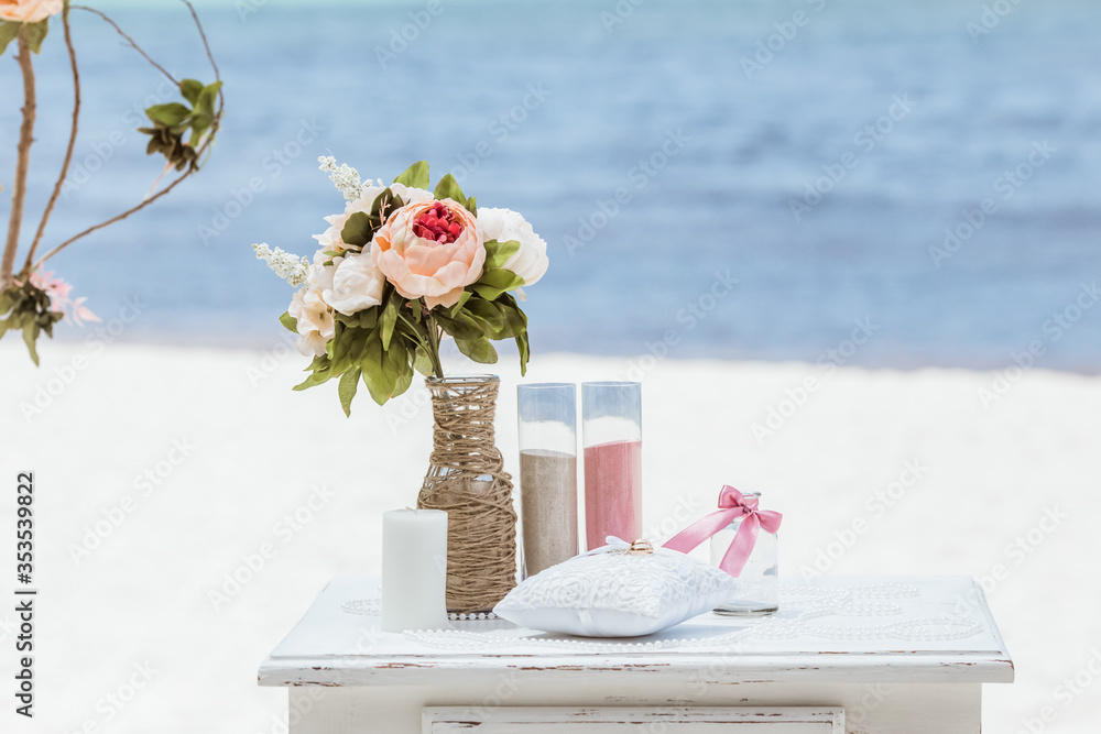 Fotografie Bride and groom pouring colorful different colored sands into the crystal vase c