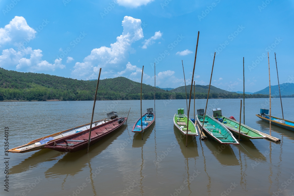 Fishing boats moored on the Mekong River on a sunny summer afternoon in Luang Prabang, Laos.