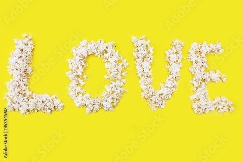 Obraz na płótnie The inscription Love is written in white flowers of lilac on a yellow background. The word love is written with lilac flowers. Flower inscription Love. Background for a greeting card. Wedding, Valenti w salonie