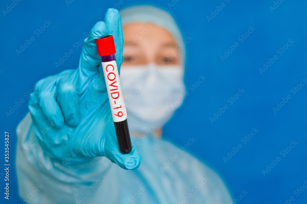 Blood test. A young medical worker holds a blood tube with the inscription covid-19 Blood test. A young medical worker holds a blood tube with the inscription covid-19