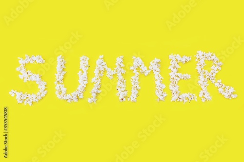 Obraz na płótnie The inscription Summer is written in white flowers of lilac on a yellow background. The word Summer is written with lilac flowers. Flower inscription Summer. Background for a greeting card. Wedding w salonie