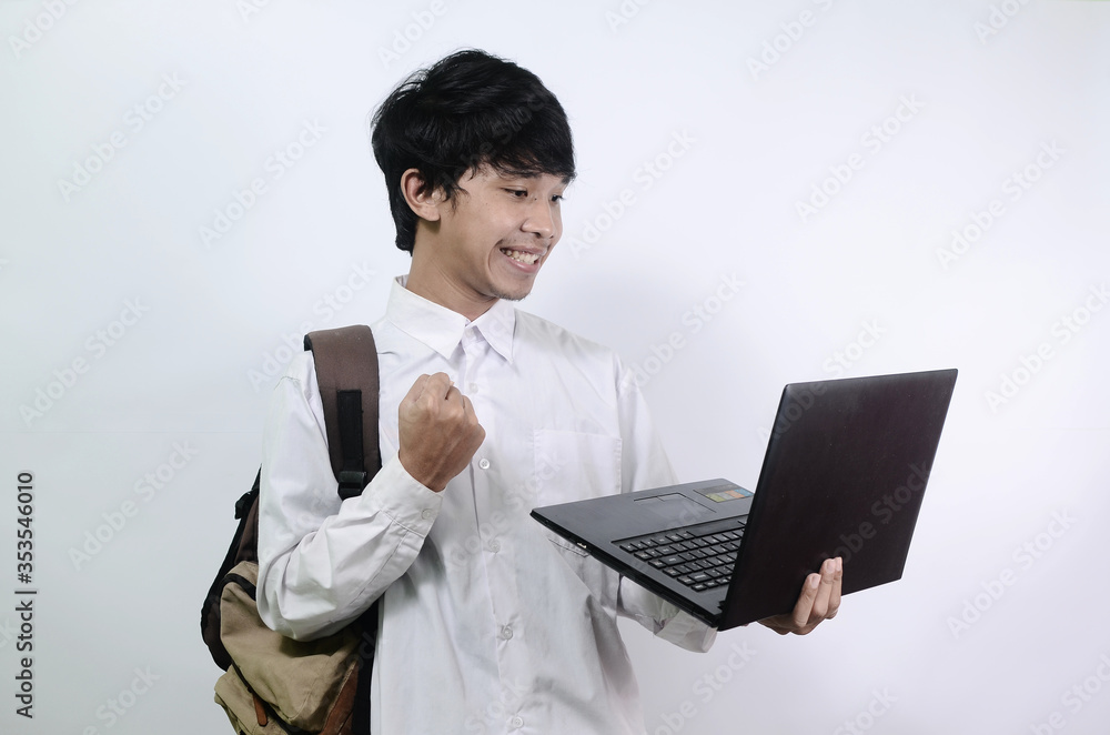 Asian man with a happy expression while holding a laptop. Young Asian men wearing white shirts isolated on a white background Asian man with a happy expression while holding a laptop. Young Asian men wearing white shirts isolated on a white background