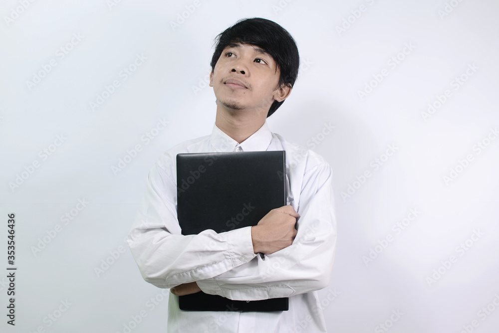Young Asian men wearing white shirts and carrying bags isolated on a white background. man is hugging his laptop
Young Asian men wearing white shirts and carrying bags isolated on a white background. man is hugging his laptop