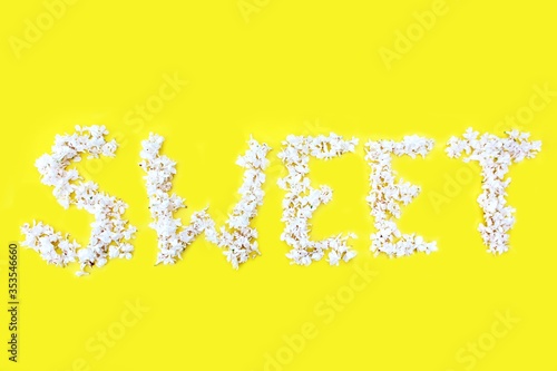 Obraz na płótnie The inscription Sweet is written in white flowers of lilac on a yellow background. The word Sweet is written with lilac flowers. Flower inscription Sweet. Background for a greeting card. Wedding w salonie