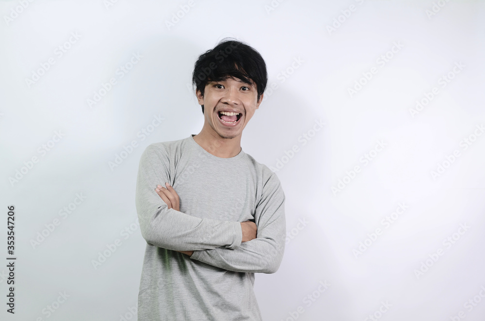 Asian men wearing gray long sleeve tshirts. Asian man is feeling happy with his mouth breath and blowing Asian men wearing gray long sleeve tshirts. Asian man is feeling happy with his mouth breath and blowing