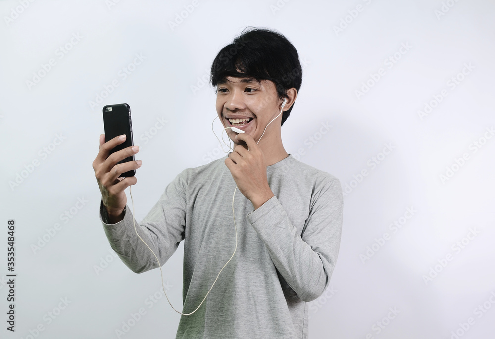 Asian man makes video calls on smartphone. Asian men wearing gray long sleeve t-shirts Asian man makes video calls on smartphone. Asian men wearing gray long sleeve t-shirts