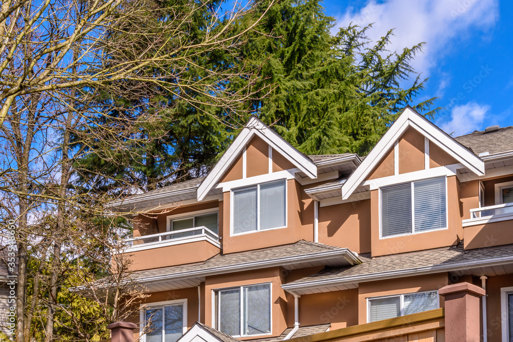 A perfect neighborhood. Houses in suburb at Summer in the north America. Top of a luxury house with nice window over blue sky. A perfect neighborhood. Houses in suburb at Summer in the north America. Top of a luxury house with nice window over blue sky.