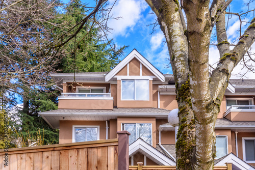 A perfect neighborhood. Houses in suburb at Summer in the north America. Top of a luxury house with nice window over blue sky.