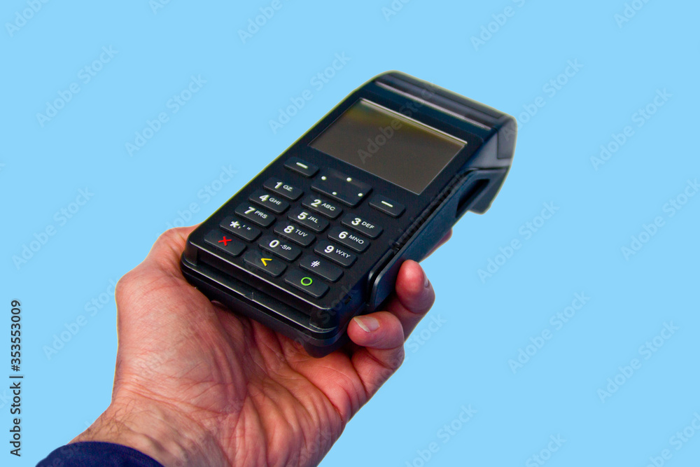 Hand is holding a credit card payment terminal on blue background. Hand is holding a credit card payment terminal on blue background.