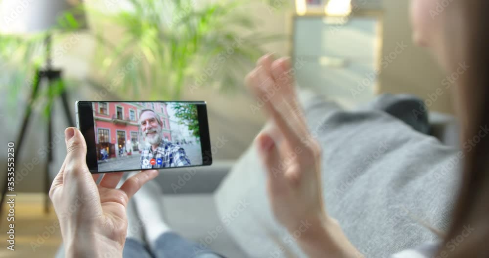 Cellphone screen with video conference between girl and her grandfather. Woman videochatting with old Caucasian man while resting indoors. Online call with senior male standing on street. Talk concept Cellphone screen with video conference between girl and her grandfather. Woman videochatting with old Caucasian man while resting indoors. Online call with senior male standing on street. Talk concept