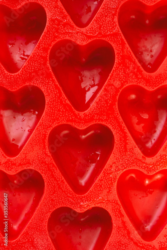 red hearts vertical background, silicone ice molds in the form of hearts.