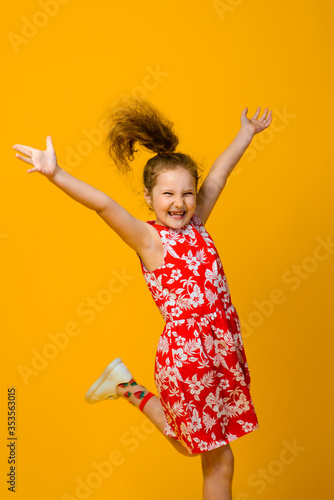 Happy carefree child emotions. Energetic joyful adorable little girl laughing at joke on yellow background.