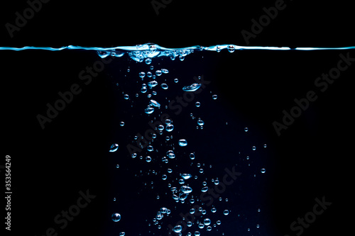 Scatter waves cause many blue bubbles in the water to dark background.