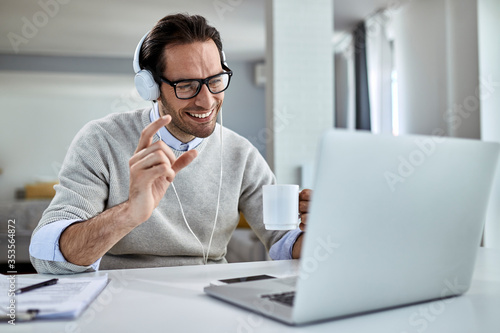 Happy freelance worker having video call over laptop at home.