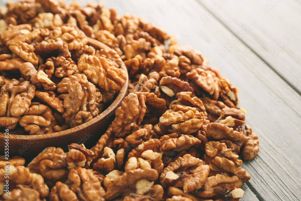 Bowl with tasty walnuts on wooden background Bowl with tasty walnuts on wooden background