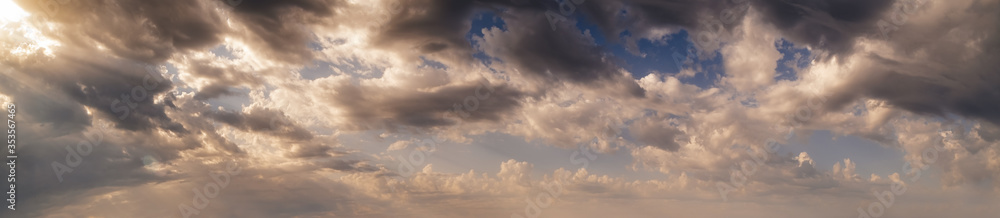 Colourful morning sky with clouds and sunrays (wide skyscape background panorama).