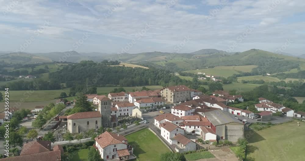 Basque town of Irissarry France with church and grain depot building seen, Aerial circle shot Basque town of Irissarry France with church and grain depot building seen, Aerial circle shot