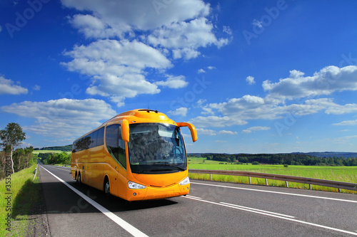 Yellow bus on the road carrynig tourists on vacation