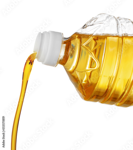 Pouring oil for cooking in a bottle isolated on white background.