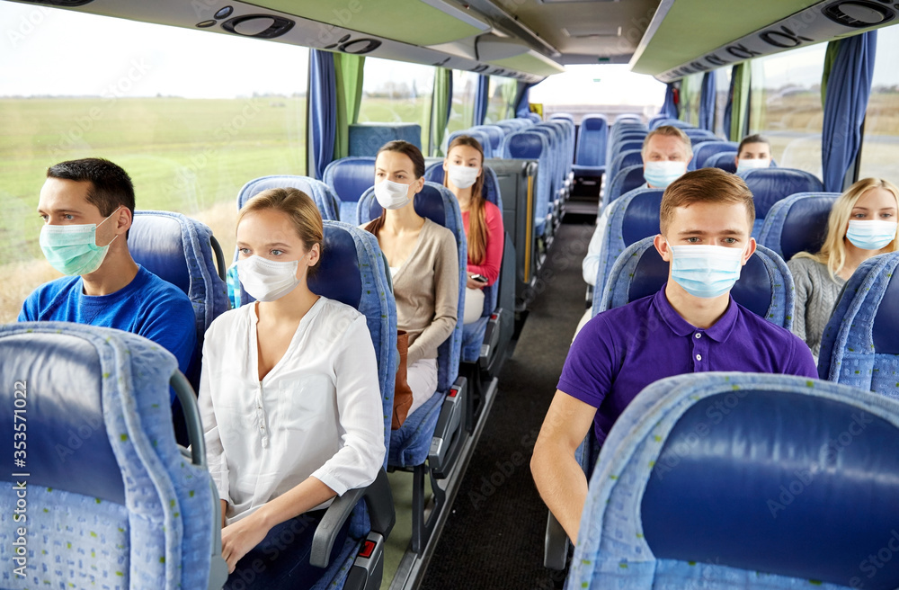 transport, tourism, road trip and people concept - group of passengers or tourists wearing face protective medical masks for protection from virus disease in travel bus - obrazy, fototapety, plakaty 