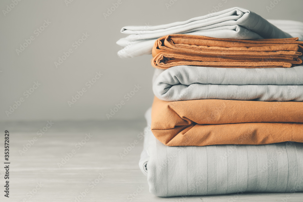Stack of clean bed sheets on table - obrazy, fototapety, plakaty 