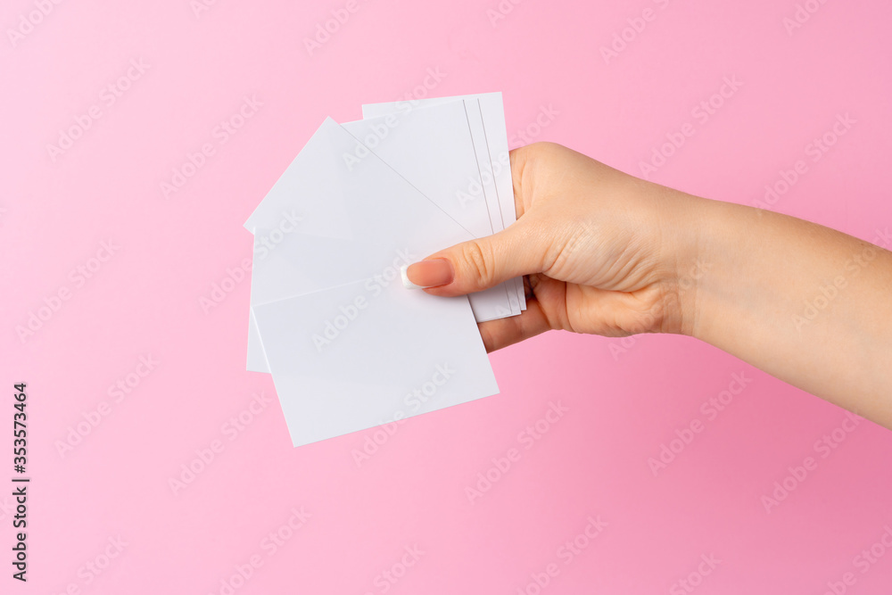 Woman hand showing blank business card on pink background. Woman hand showing blank business card on pink background.