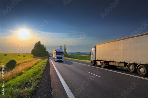 White trucks transport on the road  at sunset and cargo