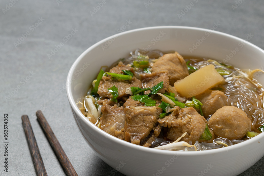 Vermicelli with beef in white bowl on concrete table. Vermicelli with beef in white bowl on concrete table.