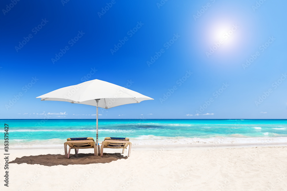 Beach chairs with umbrella and beautiful sand beach in Punta Cana, Dominican Republic