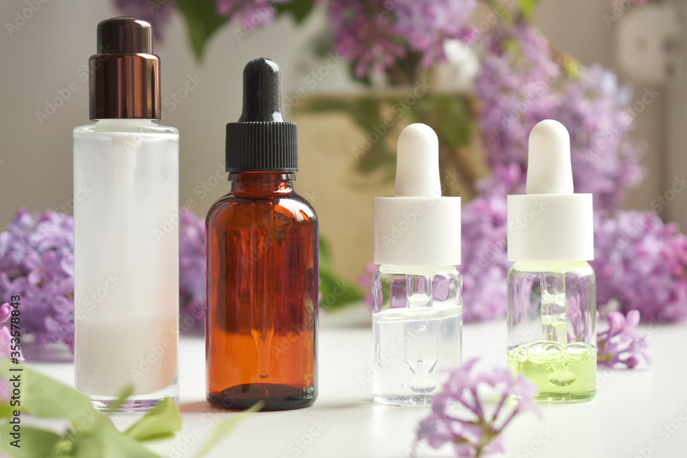 Bottles of aromatic oil with petals on the background. Basics of aromatherapy. Botanical skin care at home Spa treatment. Top view. natural medicine Bottles of aromatic oil with petals on the background. Basics of aromatherapy. Botanical skin care at home Spa treatment. Top view. natural medicine