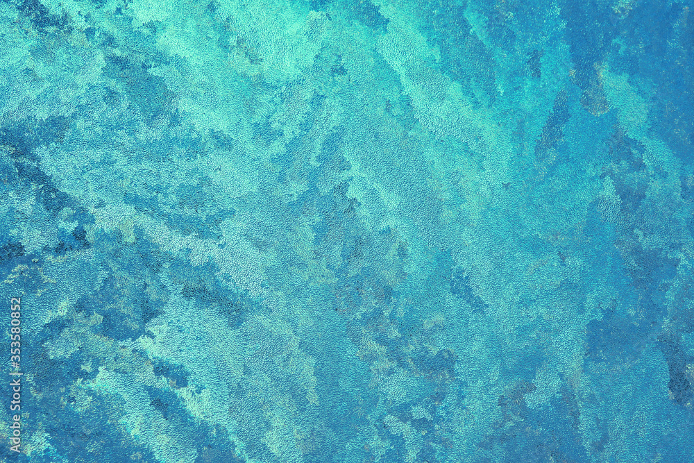 Abstract spotted turquoise, aquamarine and blue background. Chaotic spots and stains, similar to seething sea waves. Bright color background or wallpaper